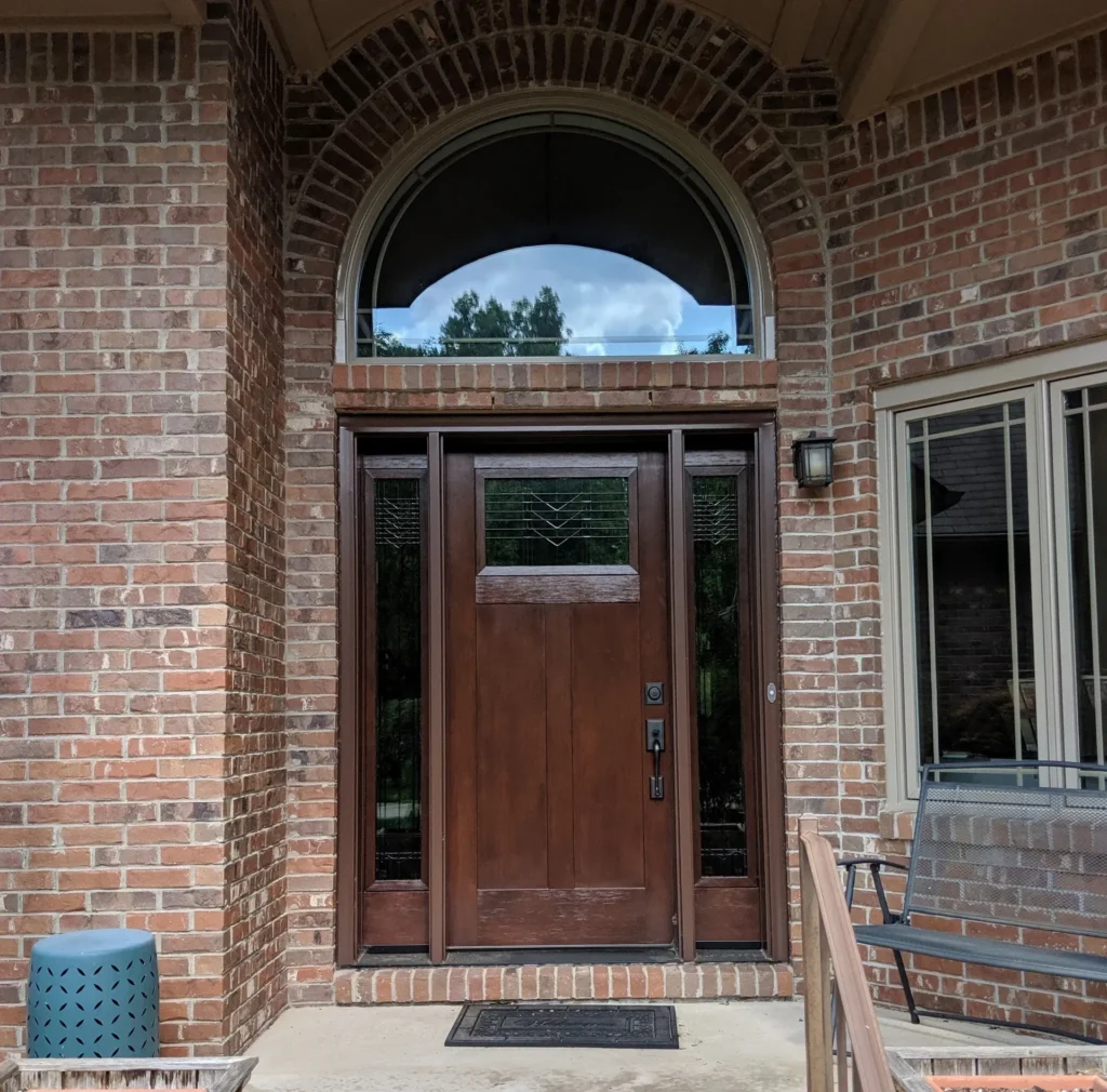 New wood entry door with decorative glass, sidelights, and transom