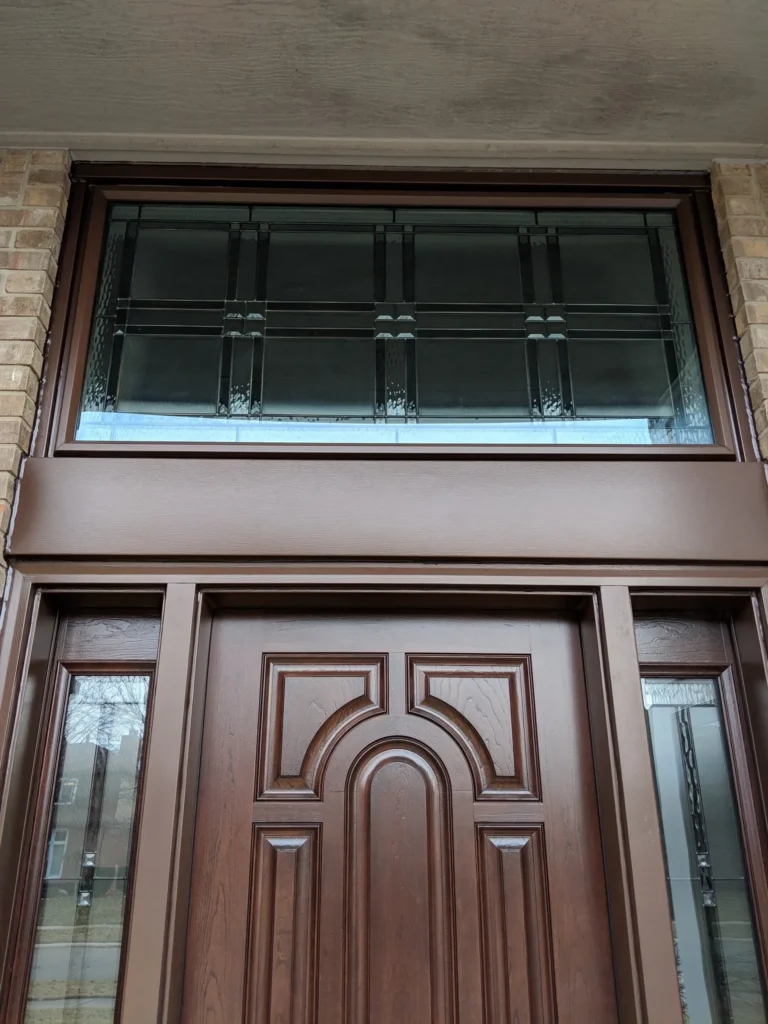 New wood entry door with decorative glass sidelights and transom