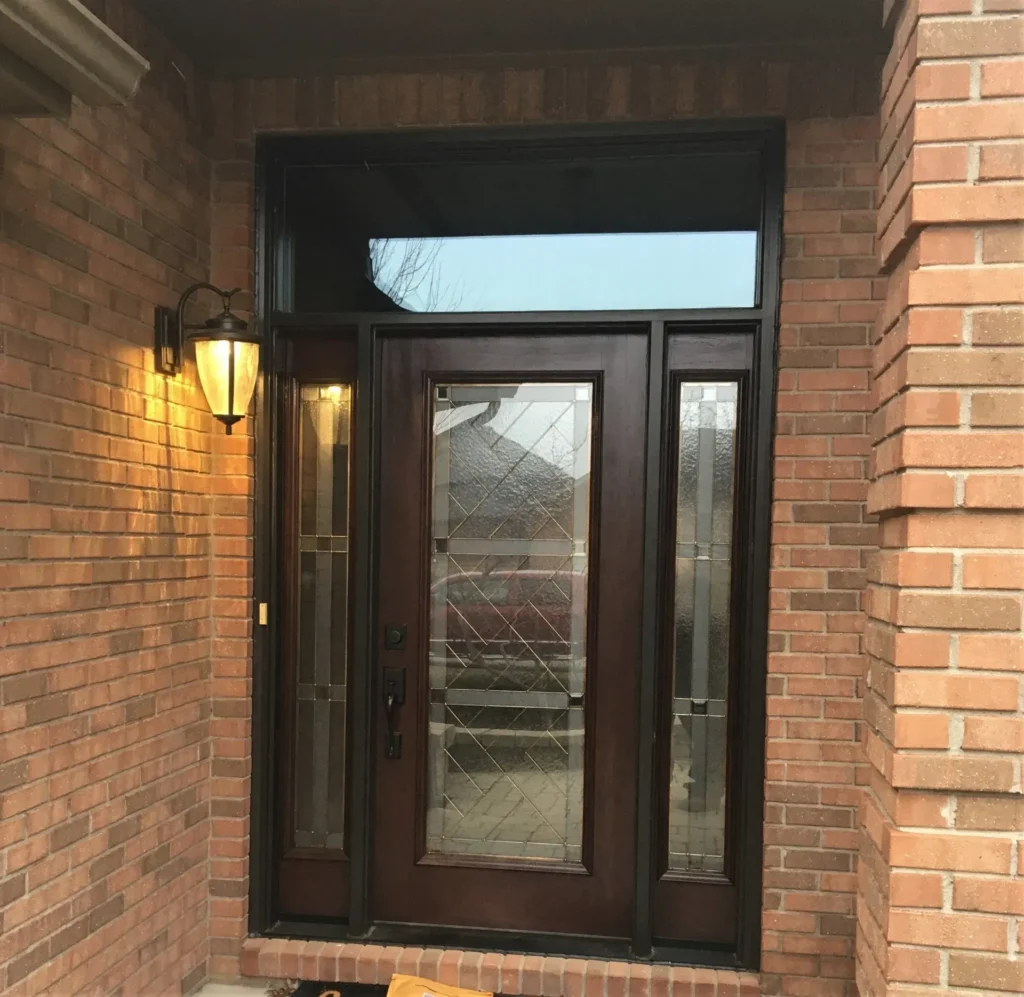 New wood entry door with decorative glass, sidelights, and transoms