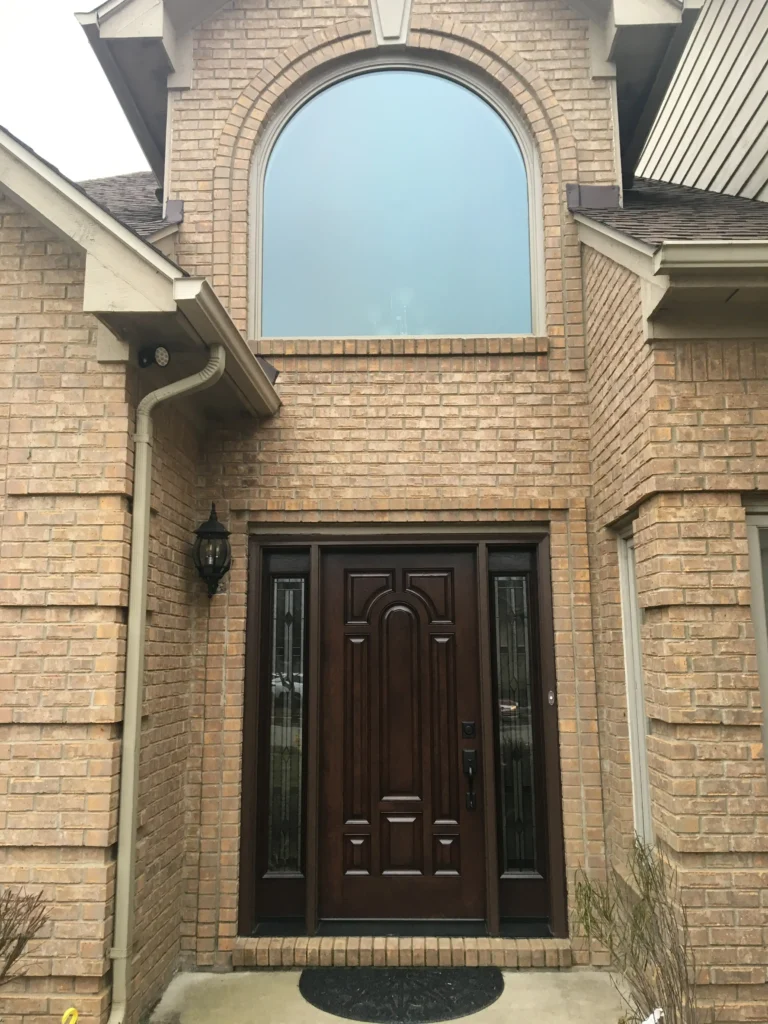 New wood entry door with decorative glass sidelights and new window above